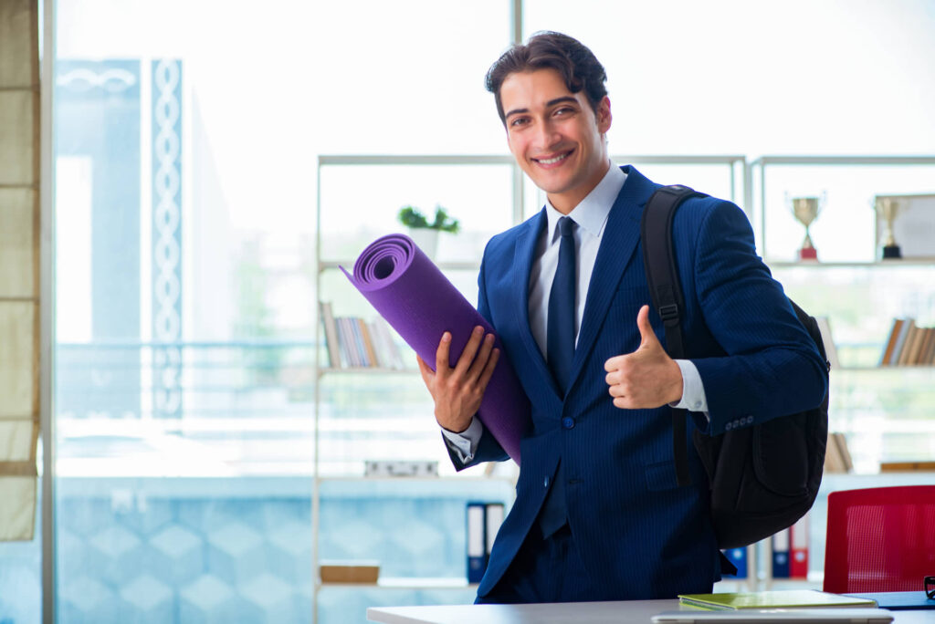 Businessman holding yoga mat